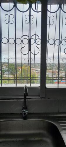 a window with a faucet in front of a window at Saloome Accommodation Mikindani in Mombasa