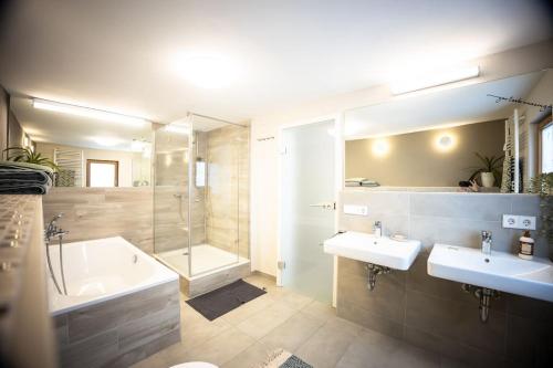 y baño con 2 lavabos, bañera y ducha. en Villa Vanilla im Burgdorf 11 P., 