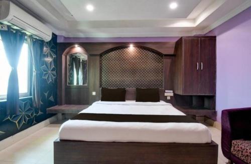 En eller flere senge i et værelse på Goroomgo Hotel Blue Royal Swimming Pool Hotel Near DN Regalia Mall