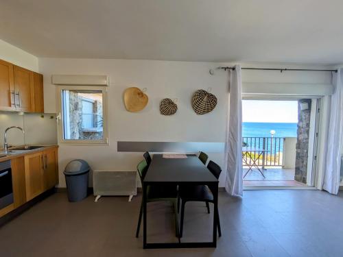 une cuisine avec une table et une vue sur l'océan dans l'établissement Appartement vue mer à 1 min à pied des plages avec parking privé, à Collioure
