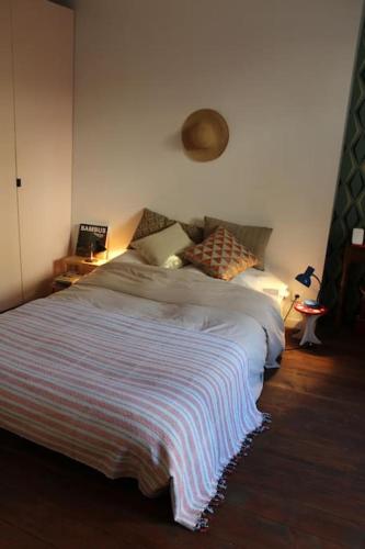 une chambre avec un lit avec une couverture rayée dans l'établissement Casa Julia, maison familiale, à Forcalquier