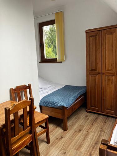 a room with a bed and a table and a window at Base Camp Pieniny in Niedzica