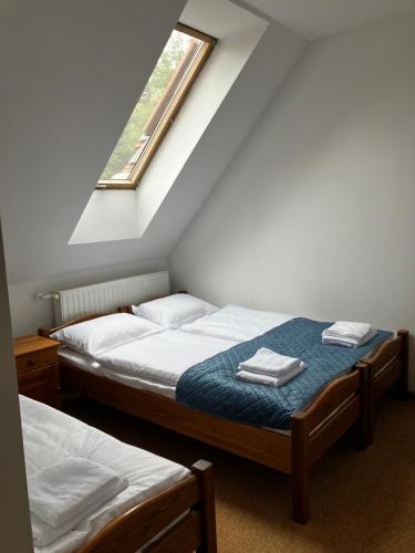 2 camas individuales en una habitación con ventana en Base Camp Pieniny en Niedzica