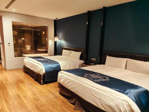 a hotel room with two beds and a walk in shower at Saint Art Hotel in Beigang