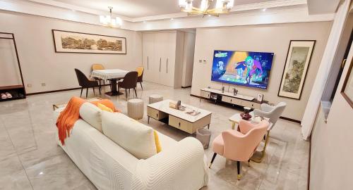 a living room with a white couch and a tv at Ancient City Wall Home Apartment Xi'an in Xi'an