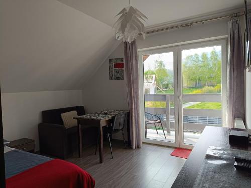 1 dormitorio con cama, mesa y ventana en Słoneczny Bliźniak en Ściegny
