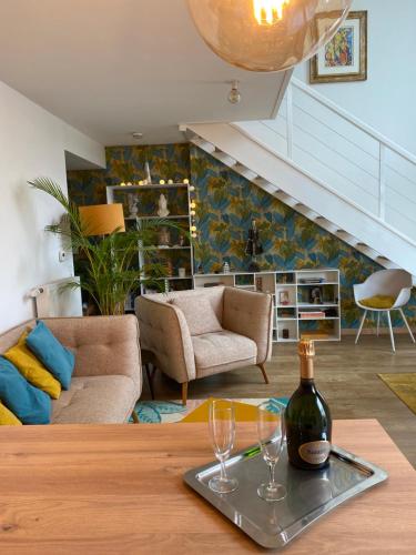 - un salon avec une table et des verres à vin dans l'établissement Appartement chic près de La Défense à 30 mn des Champs Elysées, à Bezons