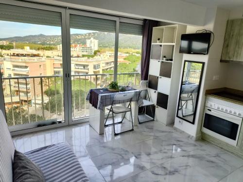 um quarto com uma mesa e uma varanda com vista em Platja d'Aro 1 BR apartment em Platja d'Aro