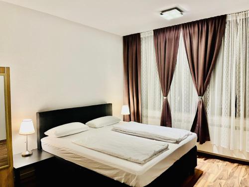 a bedroom with a bed and a window with curtains at Luxury Premium Furnished Apartment in Bonn
