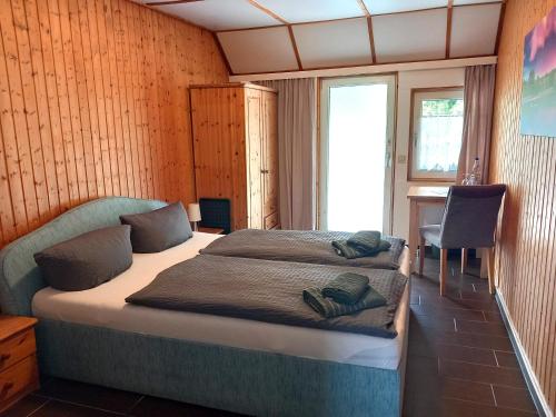 a bedroom with a bed and a desk and a window at Storchennest Spreewald in Vetschau