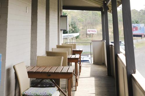 a porch with chairs and tables on a building at Royal Hotel Capertee in Capertee