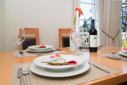 un tavolo con un piatto di cibo e una bottiglia di vino di Residence Diana a Merano