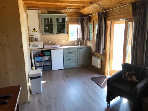 a kitchen and living room in a log cabin at Have a nice stay! - Vakantiehuis 't Klavertje in Noordwijk