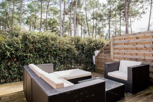 d'une terrasse avec deux chaises et une table. dans l'établissement Belle villa-patio à 700m de l'océan, à Seignosse