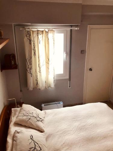 a bedroom with a bed and a window with curtains at El Molino Buñol Apartamento in Buñol