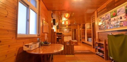a room with a table in a wooden cabin at La La Mountain Taohuayuan Farm in Hualing