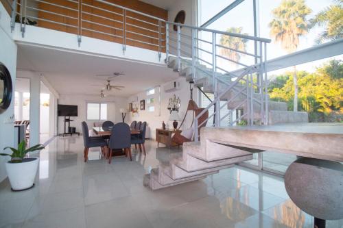 uma sala de estar com uma escada e uma sala de jantar em Pacific Shores Retreat & Getaway em Nuevo Vallarta 