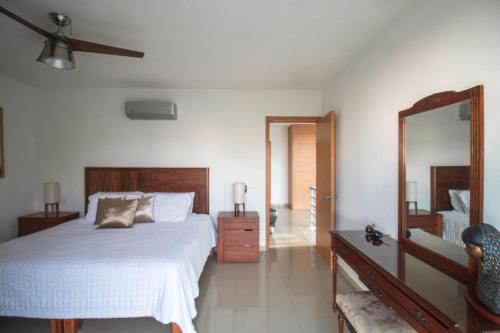 a bedroom with a white bed and a mirror at Pacific Shores Retreat & Getaway in Nuevo Vallarta 