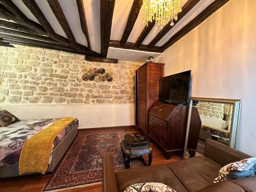 une chambre avec un lit, une télévision et un canapé dans l'établissement Studio New design by KENZO experience, à Paris