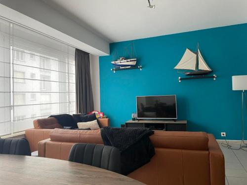 ein Wohnzimmer mit einem Sofa und einem TV in der Unterkunft Residentie Paola in Ostende