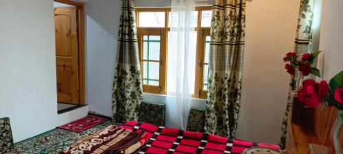 Cette chambre comprend un lit et une fenêtre. dans l'établissement The Himalayan Inn homestay, à Gulmarg