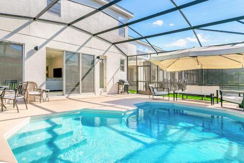 una gran piscina con techo de cristal en 10BR Luxury Home Near Disney w Pool & Games Room, en Kissimmee
