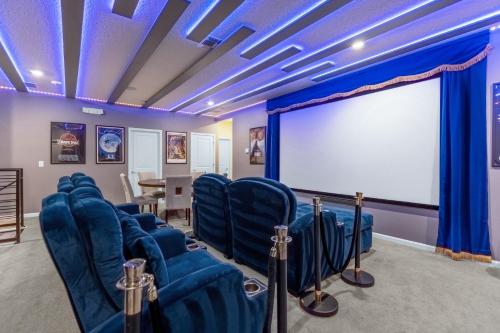 a room with blue chairs and a white screen at Upstay - 32 Guest Home - Pool, Hot Tub and Games in Kissimmee