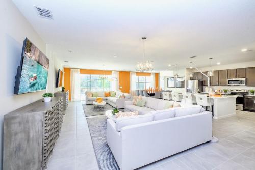 a living room with white furniture and a kitchen at Upstay - 32 Guest Home - Pool, Hot Tub and Games in Kissimmee