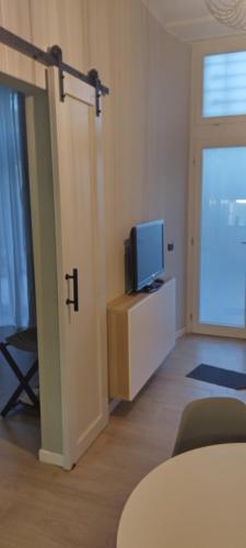 uma sala de estar com televisão e uma porta com televisão em LaCasetta em Burago di Molgora