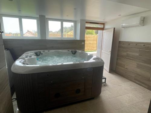a large bath tub in a bathroom with windows at Gite des 5V in Gerbépal