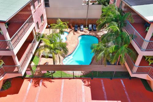 an overhead view of a pool in a hotel with palm trees at Terralong Terrace Apartments in Kiama