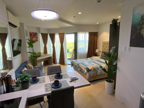 a living room with a dining table and a bedroom at Dominiks Comfort and silent Studio Tambuli Balcony Pool Mactan Ocean View High Floor in Lapu Lapu City