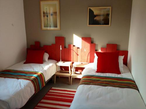 two beds in a room with red and white at Noa gris in Saint-Martin-sur-Ocre