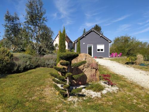 un jardin avec un rocher et une maison dans l'établissement Noa gris, à Saint-Martin-sur-Ocre