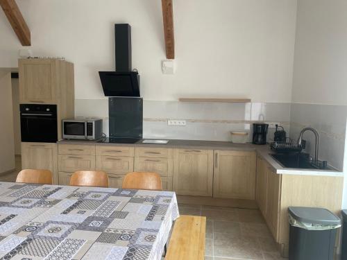 - une cuisine avec une table, des chaises et un comptoir dans l'établissement Gite des 5V, à Gerbépal