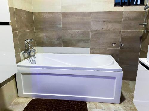 a white bath tub in a bathroom at Irish Apartment in Kasoa