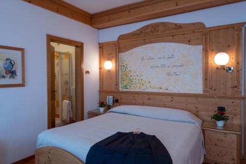 a bedroom with a large bed and a large wall at Hotel Bel Soggiorno in Malosco