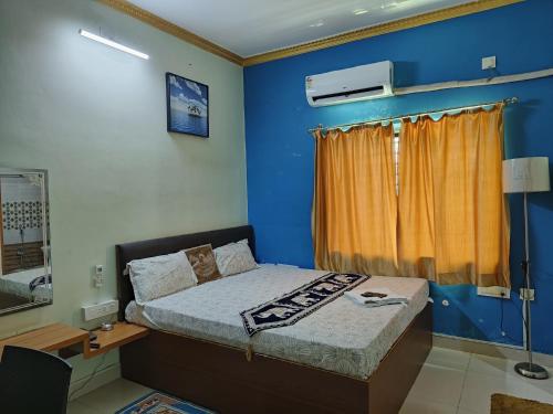 a bedroom with a bed and a blue wall at Hotel GD Stay Inn Near Mahura Chhak in Bhubaneshwar