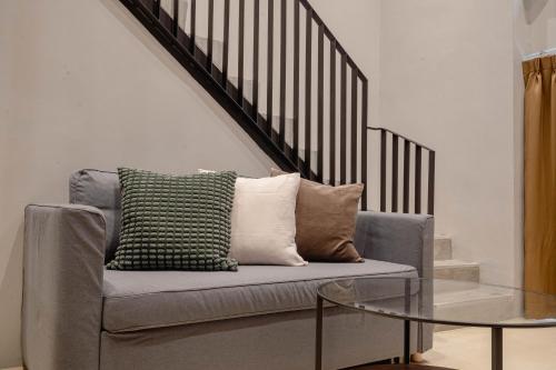 a couch with a glass table next to a staircase at Woodstory Boutique Hotel in Bangkok