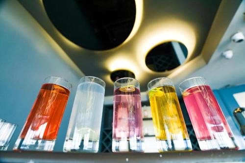a shelf with many different colored glasses on it at Hotel Grand regus in Bangalore