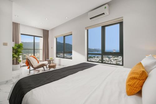 une chambre avec un grand lit et de grandes fenêtres dans l'établissement Penthouse Duplex 4 bedrooms Ocean View, Rooftop Pool, à Đà Nẵng