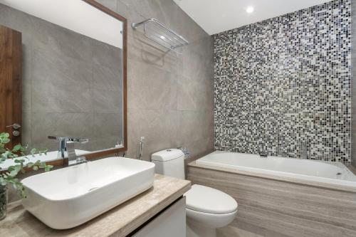 une salle de bains avec lavabo, baignoire et toilettes dans l'établissement Penthouse Duplex 4 bedrooms Ocean View, Rooftop Pool, à Đà Nẵng