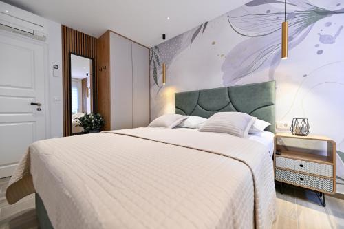 sypialnia z dużym łóżkiem i obrazem na ścianie w obiekcie Apartments and Rooms Nekic w mieście Zadar