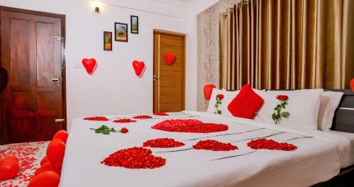 a bed with red flowers on it with hearts on it at BHRS Residency in Munnar