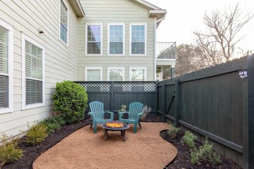 a backyard with two chairs and a table and a fence at East Austin Family Home - 5 mins from downtown in Austin