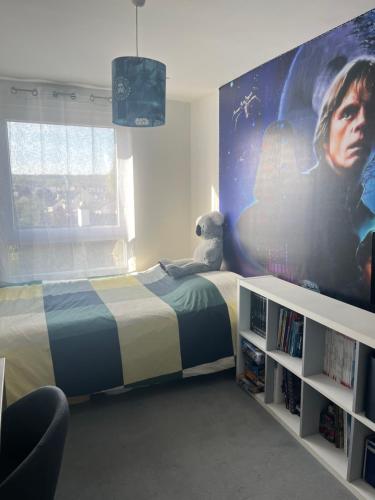 a bedroom with a bed with a movie poster on the wall at Appartement 4 personnes idéal JO 2024 in Tremblay En France