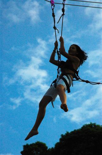 a woman is hanging on a zip line at LooLa Adventure Resort in Telukbakau