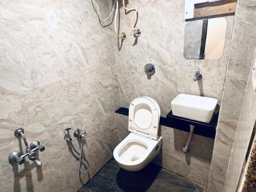 a bathroom with a toilet and a sink at HOTEL SAHYOG in Rādhanpur