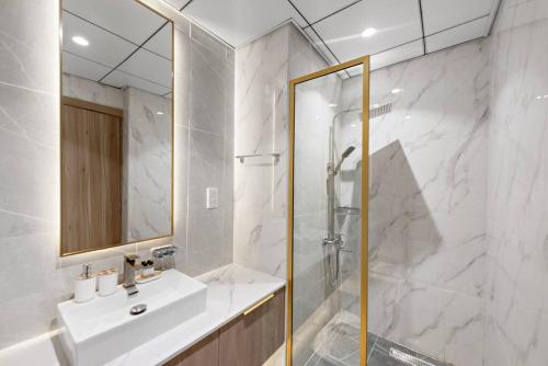 a white bathroom with a sink and a shower at Charming and Spacious Studio in Dubai