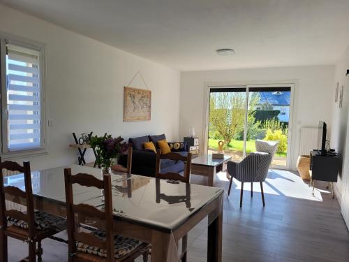 une cuisine et un salon avec une table et des chaises dans l'établissement Bienvenue chez Sylvie, à Martigné-Briand
